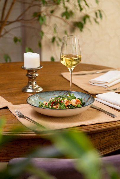 salade fraîche servie avec un verre de vin. table servie - Photo, image