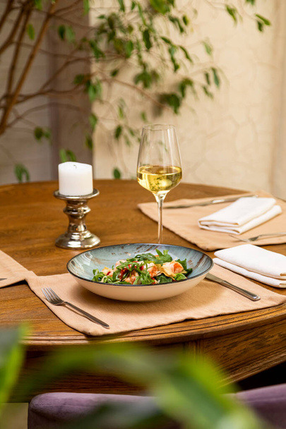 ensalada fresca servida con una copa de vino. mesa servida - Foto, Imagen