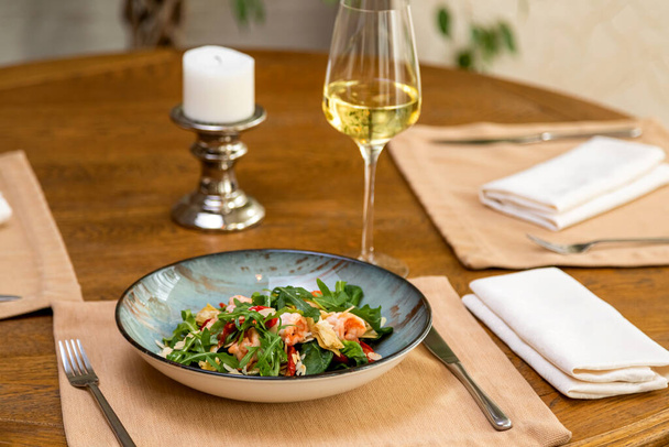 Bir bardak şarapla servis edilen taze salata. servis masası - Fotoğraf, Görsel