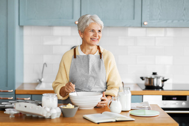 happy woman cooking food on kitchen at home - Φωτογραφία, εικόνα