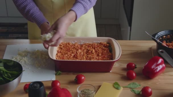 Γυναίκα βάζει στρώμα τυριού σε ορεκτικό γεύμα - Πλάνα, βίντεο