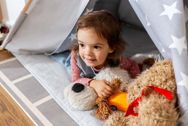 baby girl playing with toys in or teepee at home - Foto, Imagen