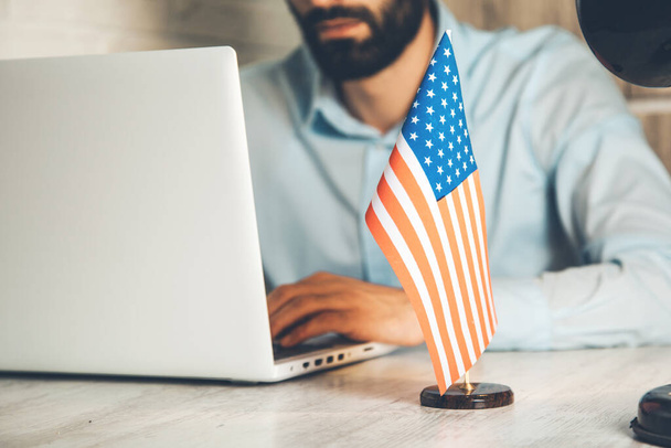 man working in computer with american flag on desk - Φωτογραφία, εικόνα