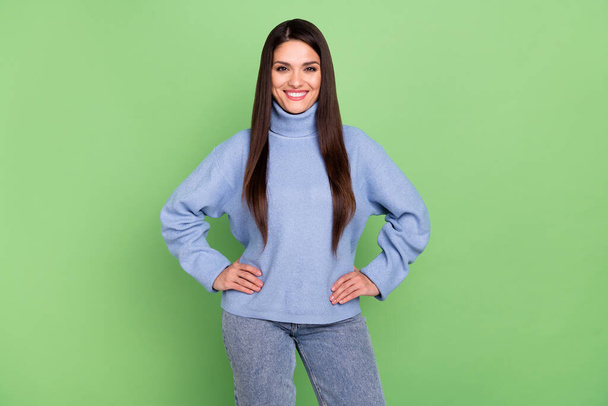 Photo of sweet adorable young woman wear blue sweater smiling walking arms waist isolated green color background - Fotografie, Obrázek