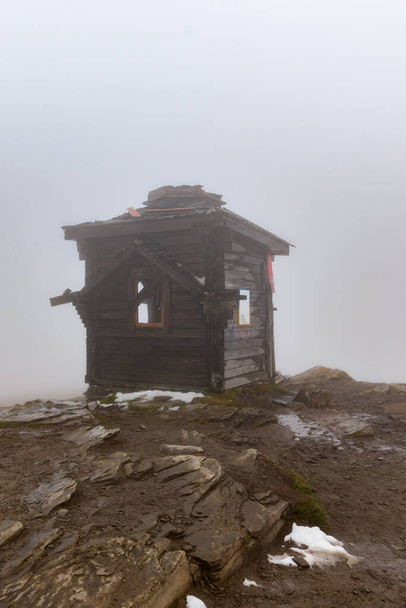 The top of Mount Petros, the Christian cross and the inactive chapel on top of the mountain, the top of the mountain in fog and snow. - Fotó, kép