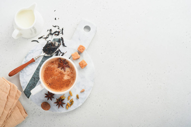 Masala tea. Masala chai fűszerezett teát tejjel és fűszerekkel világosszürke háttérrel. Hagyományos indiai ital. Fűszeres ital. Másold a helyet. Felülnézet. - Fotó, kép