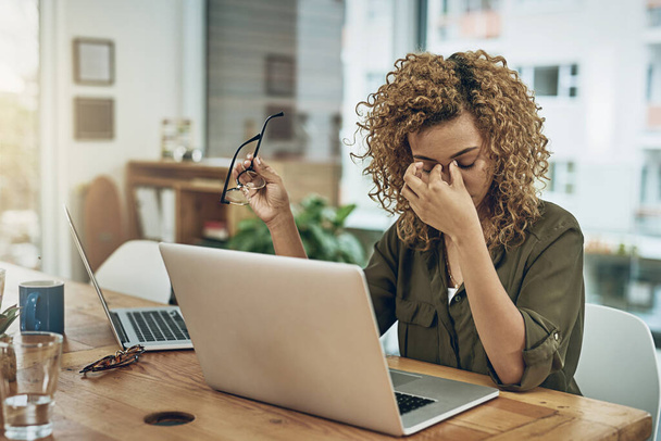 Kun tie menestykseen johtaa stressiin. Kuvattu nuori nainen kärsii stressistä, kun käytät tietokonetta hänen työpöydällään. - Valokuva, kuva