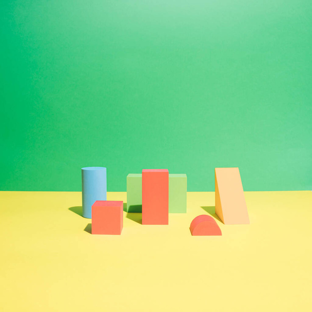 Set von farbenfrohen geometrischen Objekten auf gelbem und grünem Hintergrund. Zusammensetzung abstrakter Muster nach Form und Form. Ausbildung, Business-Lösung, kreatives Design Produktkonzept. - Foto, Bild