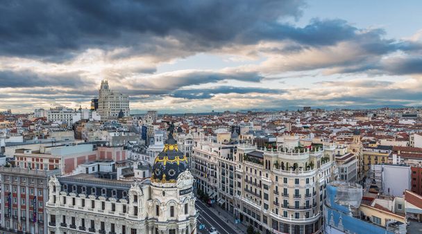 MADRID - OCTOBER 5, 2021: Aerial view of Gran Via and Madrid skyline on a cloudy afternoon, with the Metropolis building to be recognized in the foreground. - Fotó, kép