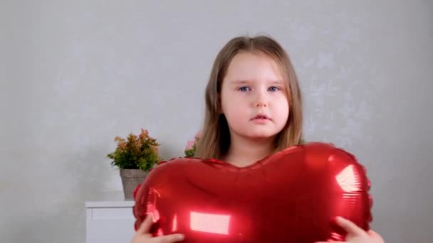 Pretty cute girl holding heart shaped crane balloons on valentines day. - Felvétel, videó