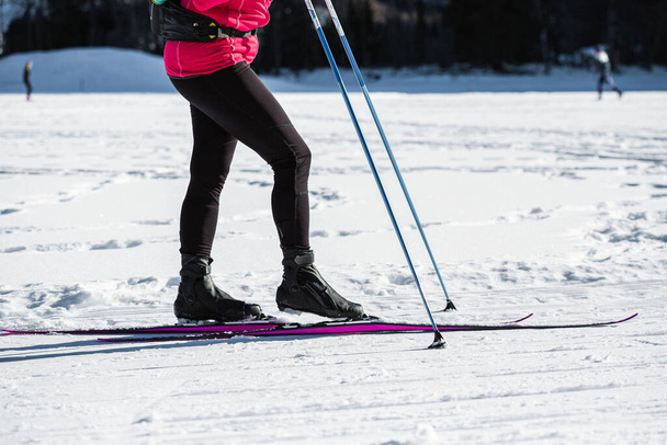 Female recreational cross-country skier rides skis on the empty trail - Foto, afbeelding
