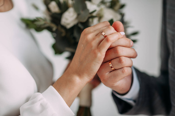 The hands of the newlyweds gently touch each other. - Zdjęcie, obraz