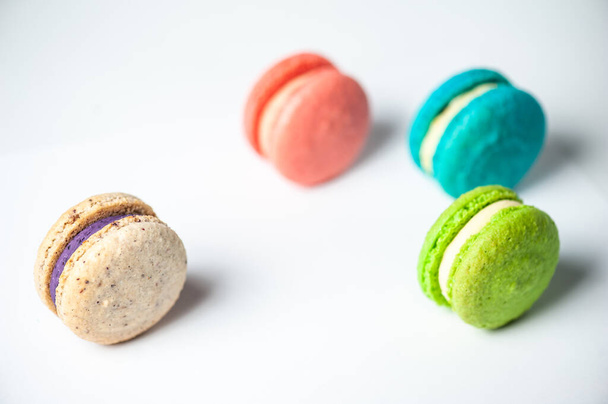 Close-up of macarons cakes of different colors in blue background. Culinary and cooking concept. Tasty colourful macaroons. - Foto, Imagem