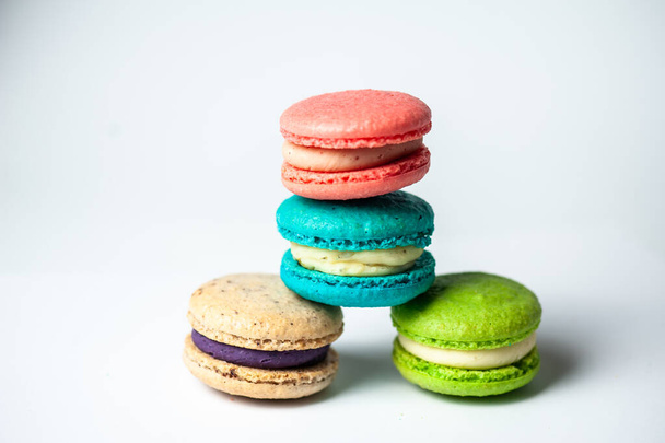 Close-up van macarons taarten van verschillende kleuren in blauwe achtergrond. Culinair en kookconcept. Lekkere kleurrijke ara 's. - Foto, afbeelding