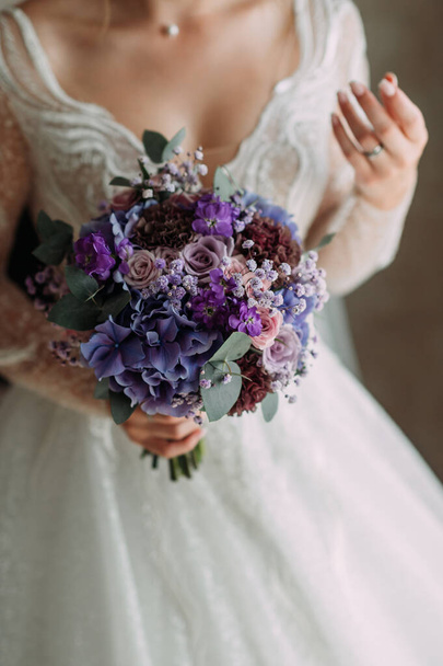 A bright purple bouquet in womens hands. - Photo, Image