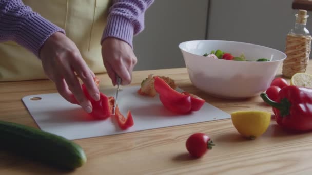 Woman is cooking at home, making fresh vegetarian salad from organic vegetables, slicing red sweet pepper, Close up, Slow motion. - Footage, Video