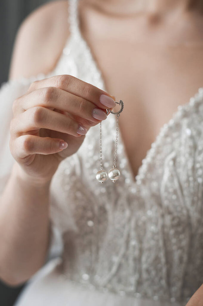 The bride wears pearl earrings for the holiday. - Fotografie, Obrázek