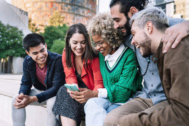 Glückliche Freunde teilen Social-Media-Inhalte per Smartphone-App. Diverse junge Leute haben Spaß mit dem Internet in einer modernen Stadt Barcelona - Foto, Bild