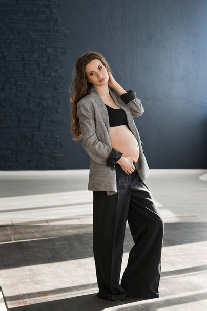 Photo of a pregnant girl in a photo studio. - Фото, изображение