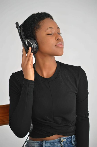 African American Women Listing to audio on studio head phones - Photo, Image