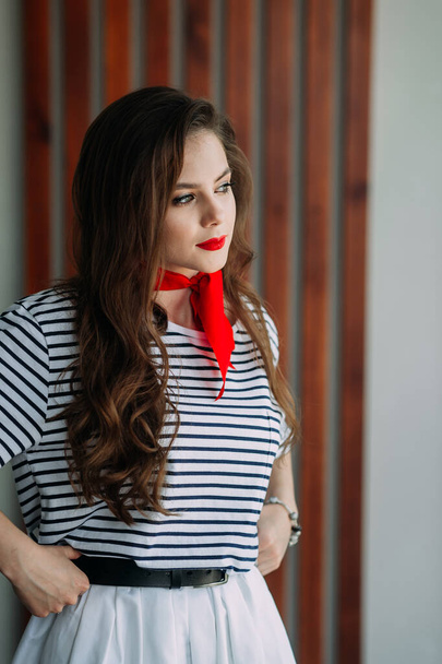 A perky girl in a striped T-shirt with a red tie. - Foto, Imagem