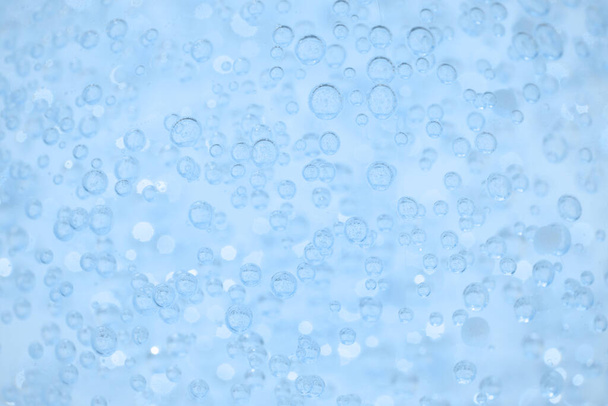 Γαλάζια διάφανη υφή καλλυντικού τζελ ή ορού προσώπου ως φόντο με φυσαλίδες και χώρο αντιγραφής. Bath καλλυντικά τζελ φόντο - Φωτογραφία, εικόνα