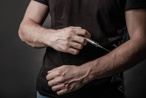 Drug concept. Syringe drug addict injecting heroin. Hands with veins close up - Photo, Image