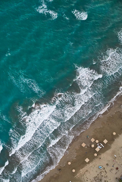 Bright blue colored sea top down aerial view. Waves on the beach. Sea waves and sandy beach. Evening surf - Photo, Image