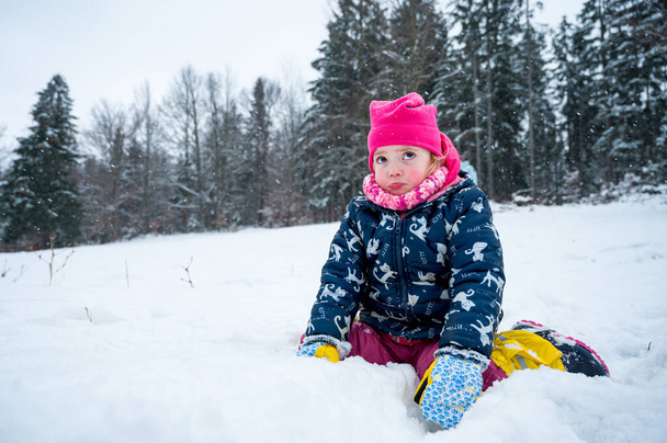 Ritratto di una ragazza triste seduta nella neve abbastanza miseramente. - Foto, immagini
