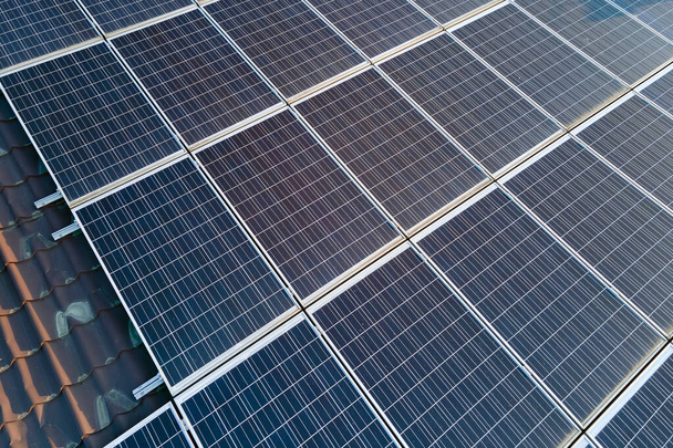 Aerial view building roof with rows of blue solar photovoltaic panels for producing clean ecological electric energy. Renewable electricity with zero emission concept - Foto, afbeelding