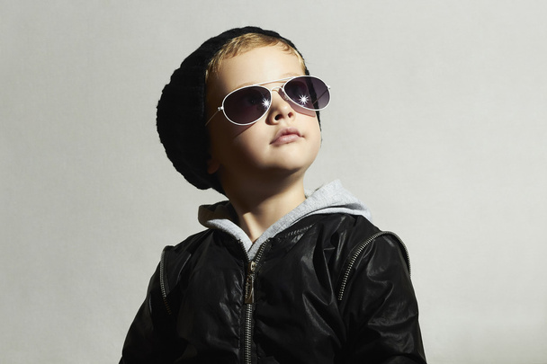 Niño de moda en gafas de sol. Niño en negro cap.winter style.Posing Little boy.Children moda
 - Foto, imagen