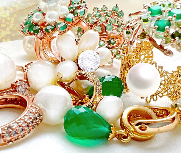 σμαράγδι greek λευκό μαργαριτάρι χρυσά δαχτυλίδια και φορώντας κοσμήματα σε λευκό φόντο - Φωτογραφία, εικόνα