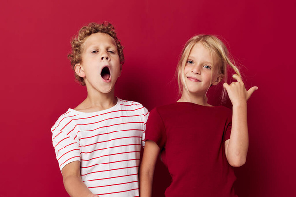 Portrait of cute children emotions stand side by side in everyday clothes red background. High quality photo - Fotó, kép