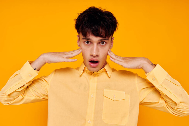 cheerful man in yellow shirt posing fashion gesture with hands. High quality photo - Fotoğraf, Görsel