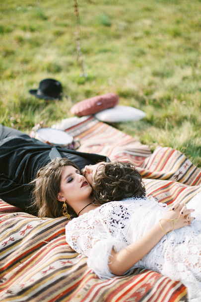 Nevěsta a ženich leží na nesourodém lůžku na zelené trávě. Kvalitní fotografie - Fotografie, Obrázek