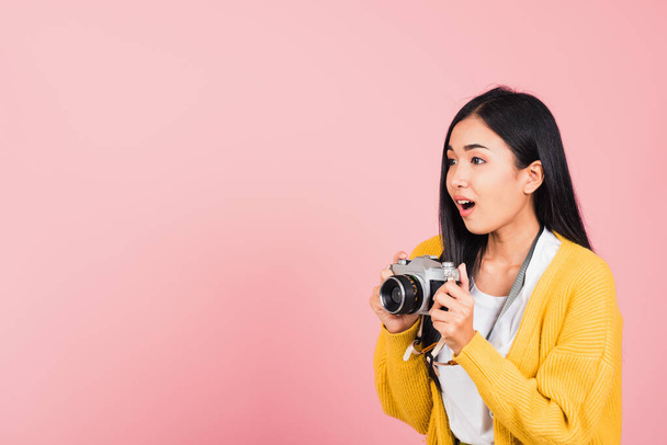 Attractive happy Asian portrait lifestyle beautiful young woman excited smiling photographer holding retro vintage photo camera ready to shoot isolated on pink background, tourism and vacation concept - Foto, Imagen