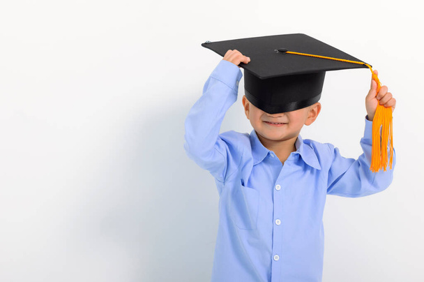 Happy Kid boy in graduation cap and cover eyes - Фото, изображение