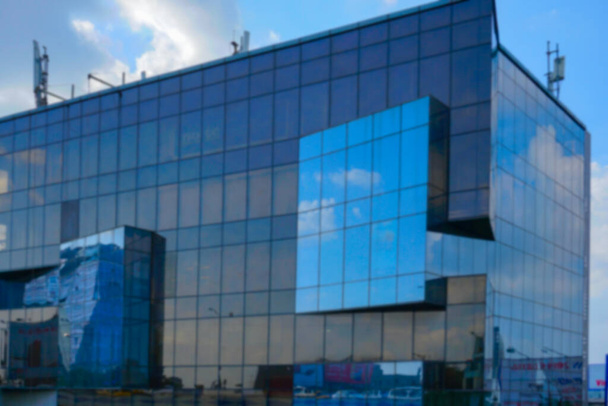 Unscharfes Bild von Kalkutta, Westbengalen, Indien. Moderne Architektur der Gebäude, Glasfassade, die den blauen Himmel reflektiert, weiße Wolken und andere Gebäude. - Foto, Bild