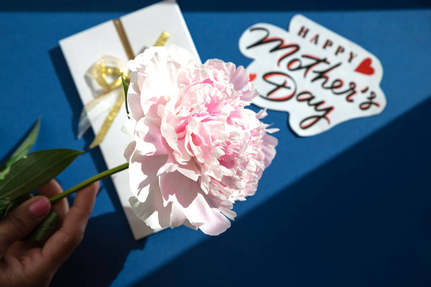 texto feliz día de las madres en ramo de peonías rosa sobre fondo rústico de madera blanca, vista superior. - Foto, imagen