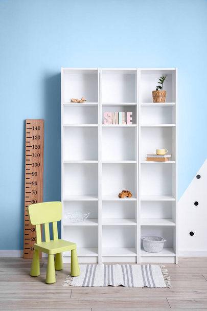 Modern shelf unit and chair in room - Photo, Image