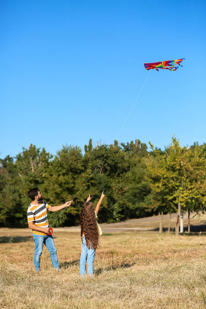 Przystojny mężczyzna puszczający latawiec ze swoją córeczką na zewnątrz - Zdjęcie, obraz