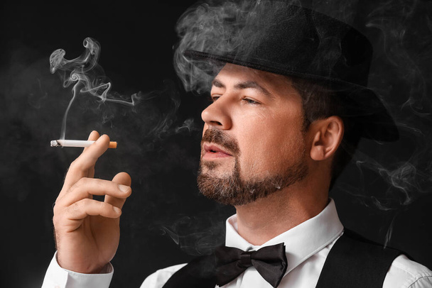 Smoking man on black background - Photo, image