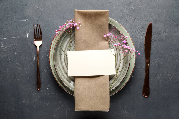 Table setting with gypsophila flowers and blank card on dark background - Photo, Image
