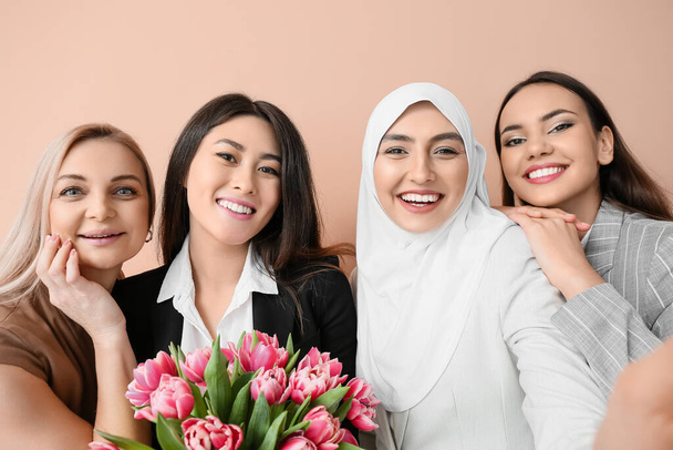 Schöne Frauen mit Blumen beim Selfie auf farbigem Hintergrund. Feier zum Internationalen Frauentag - Foto, Bild