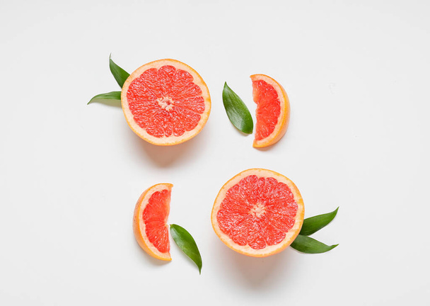 Fresh grapefruit pieces on white background - 写真・画像