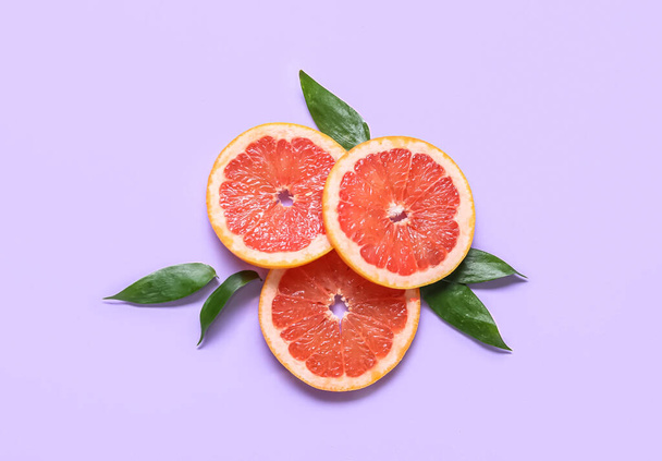 Fresh grapefruit slices on purple background - Photo, Image