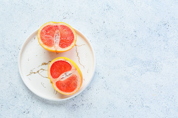 Plate with tasty cut grapefruit on light background - Photo, Image