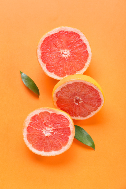 Piezas de pomelo fresco sobre fondo naranja - Foto, imagen