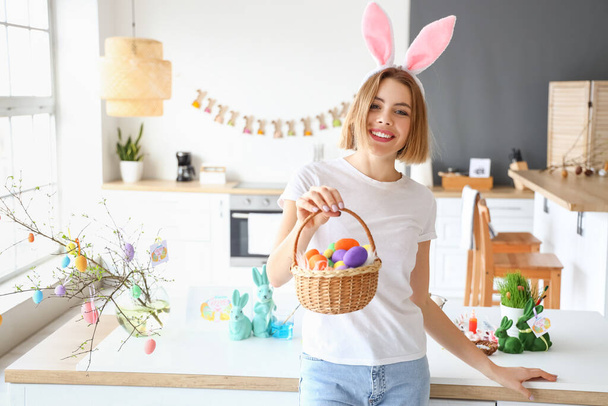 Beautiful woman with bunny ears and Easter basket at home - Fotoğraf, Görsel