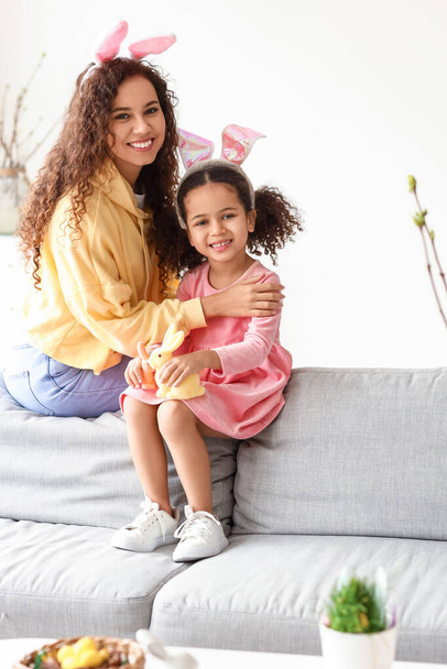 Pieni afroamerikkalainen tyttö pääsiäiskanien ja hänen äitinsä kanssa kotona - Valokuva, kuva